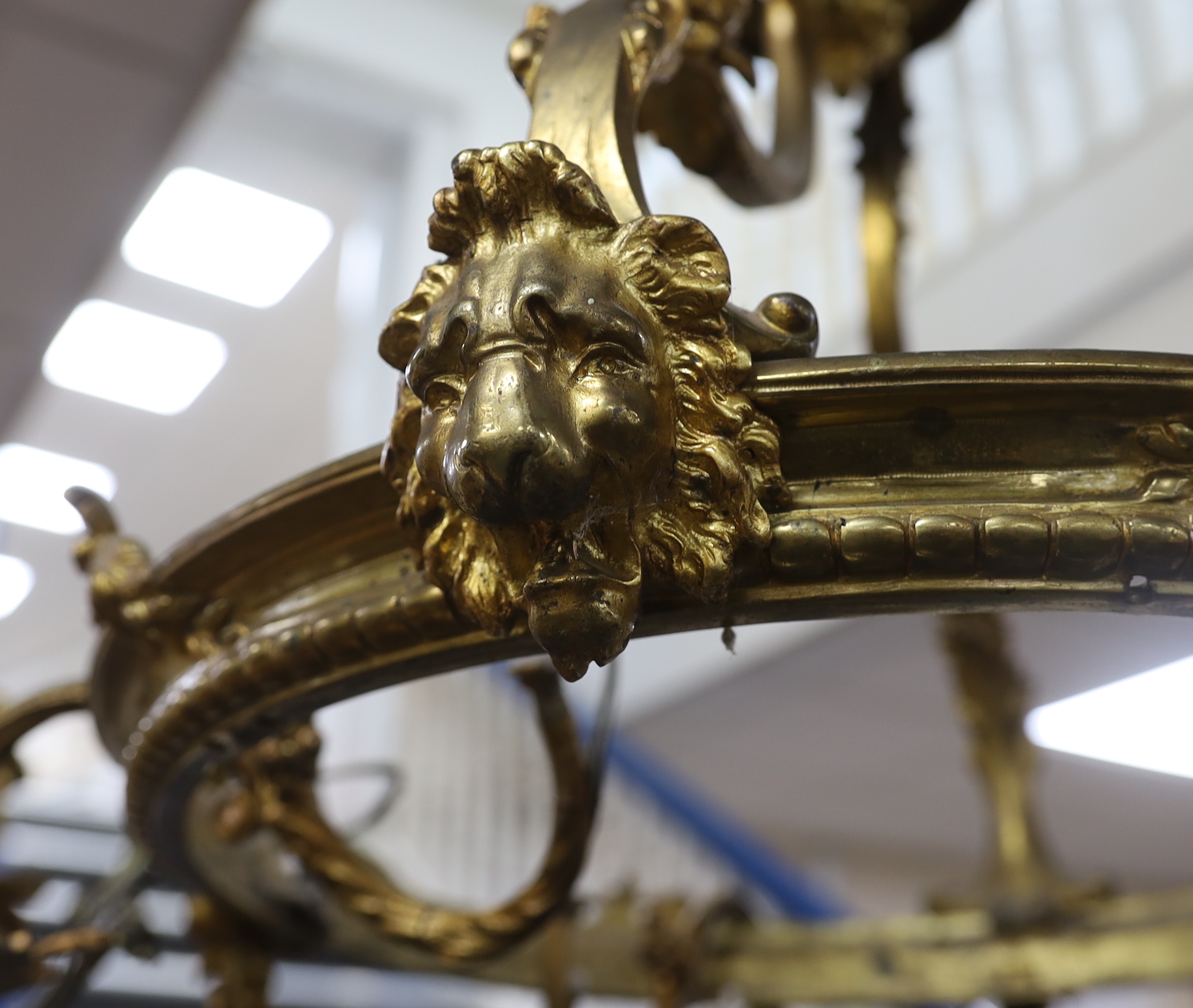 A gilt metal five branch chandelier, decorated with masks, 78cm high